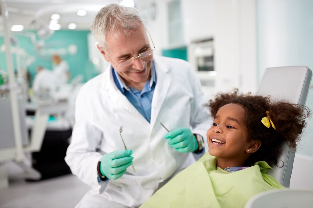 Pediatric dentist with a happy child patient